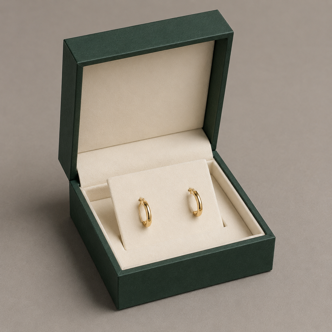 Custom earring box with cream fitted insert holding a matched pair of gold hoop earrings